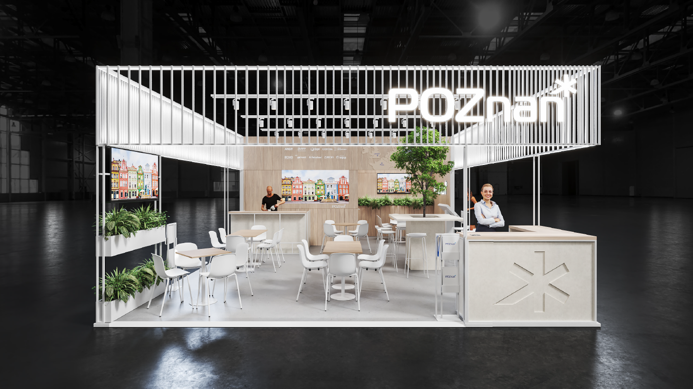 Nowoczesne stoisko wystawowe z minimalistycznym designem. Białe meble, w tym stoły, krzesła i lada barowa. Wiele roślin, w tym drzewo, dodaje zieleni do przestrzeni. Dwa duże ekrany wyświetlają kolorowe obrazy budynków, prawdopodobnie przedstawiające krajobraz miejski. Słowo "POZnań" wyświetlone w podświetlanych literach u góry stoiska.