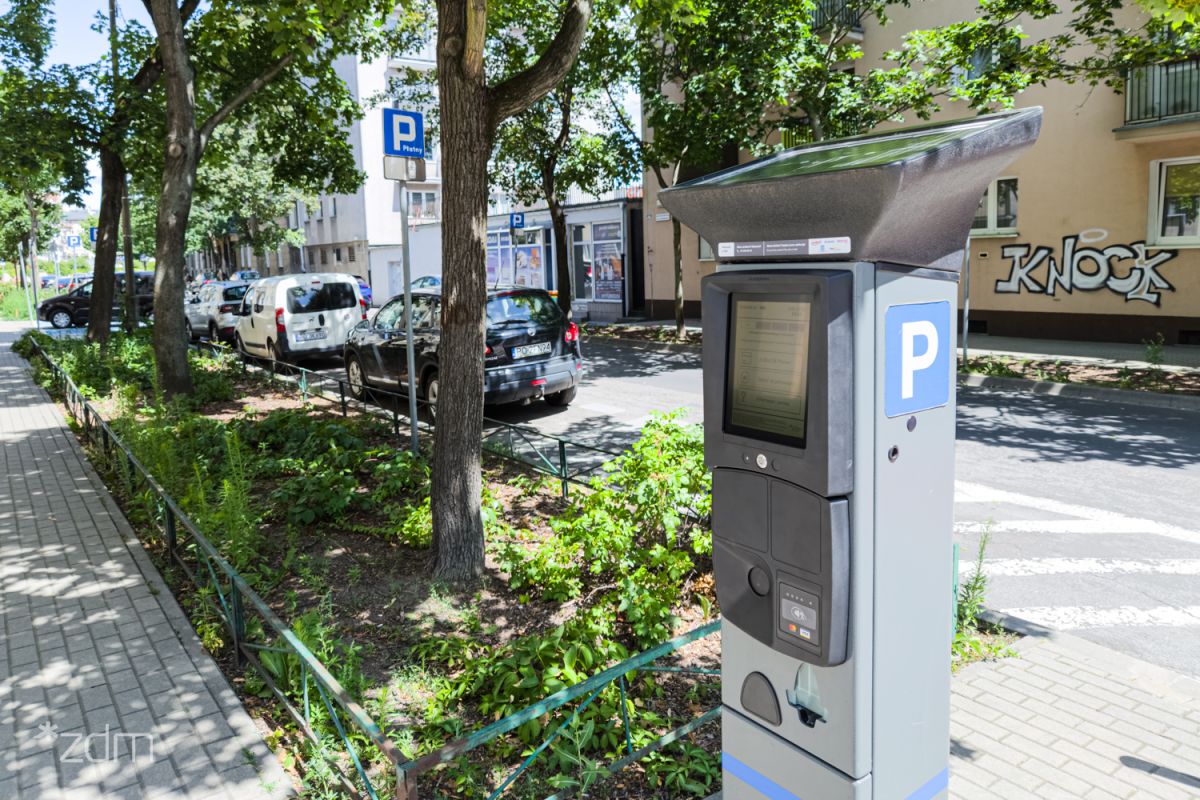 Nowy parkomat stojący przy ulicy. Widać też zieleń