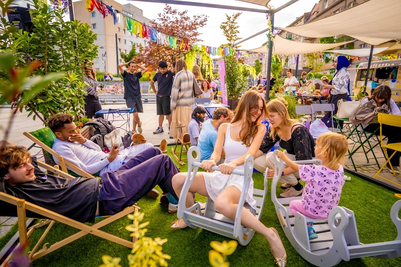 Oobyw różnym wieku siedzące korzystające ze strefy odpoczynku - siedzą na leżakach, krzesłach, rozmawiają ze sobą.