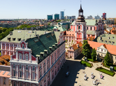 Panorama Poznania z lotu ptaka przedstawiająca barokowy zespół pojezuicki z Bazyliką Kolegiacką i Urzędem Miasta oraz placem Kolegiackim w słoneczny dzień.