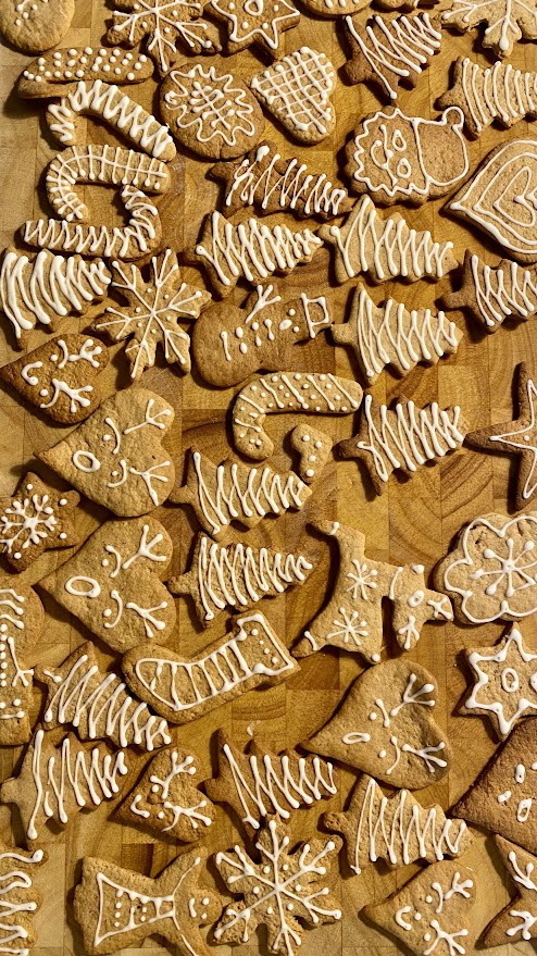 Pierniczki udekorowane lukrem na drewnianej desce.