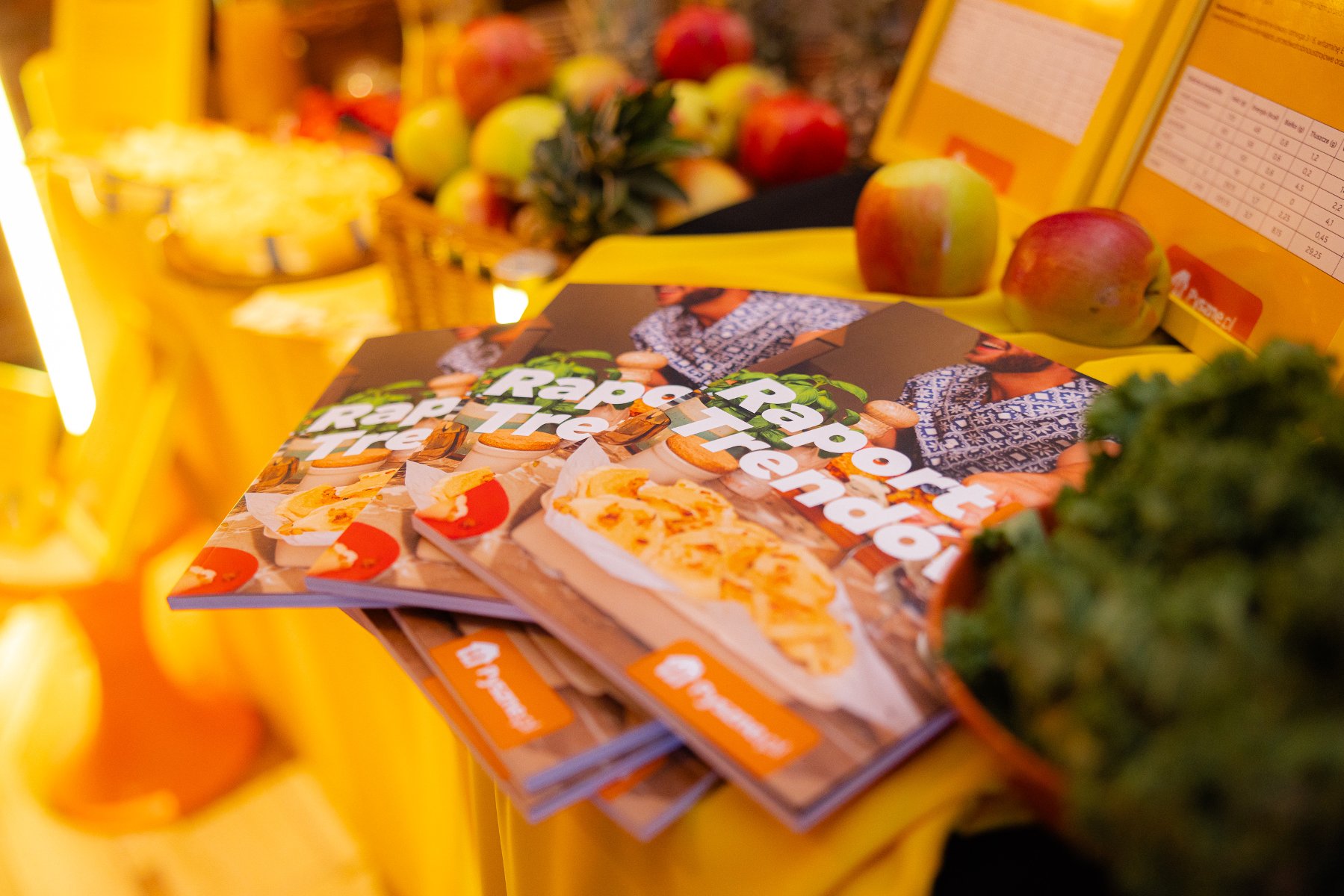 Pomiędzy owocami leży stos broszur - Raport trendów.