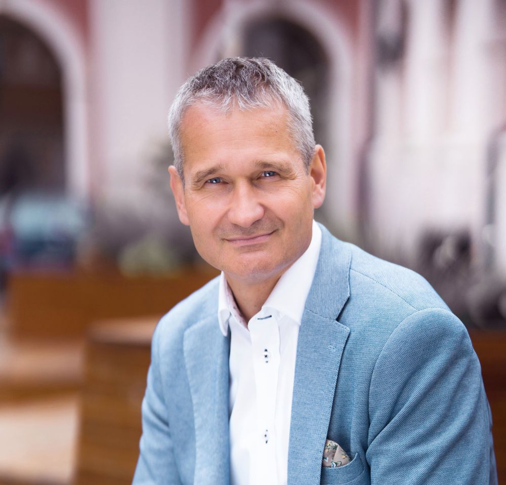 Portret mężczyzny w jasnoniebieskim garniturze.