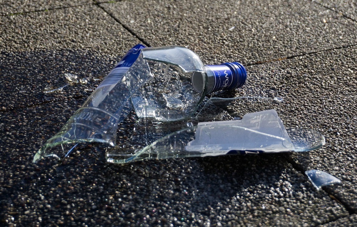 rozbita butelka po alkoholu leży na chodniku