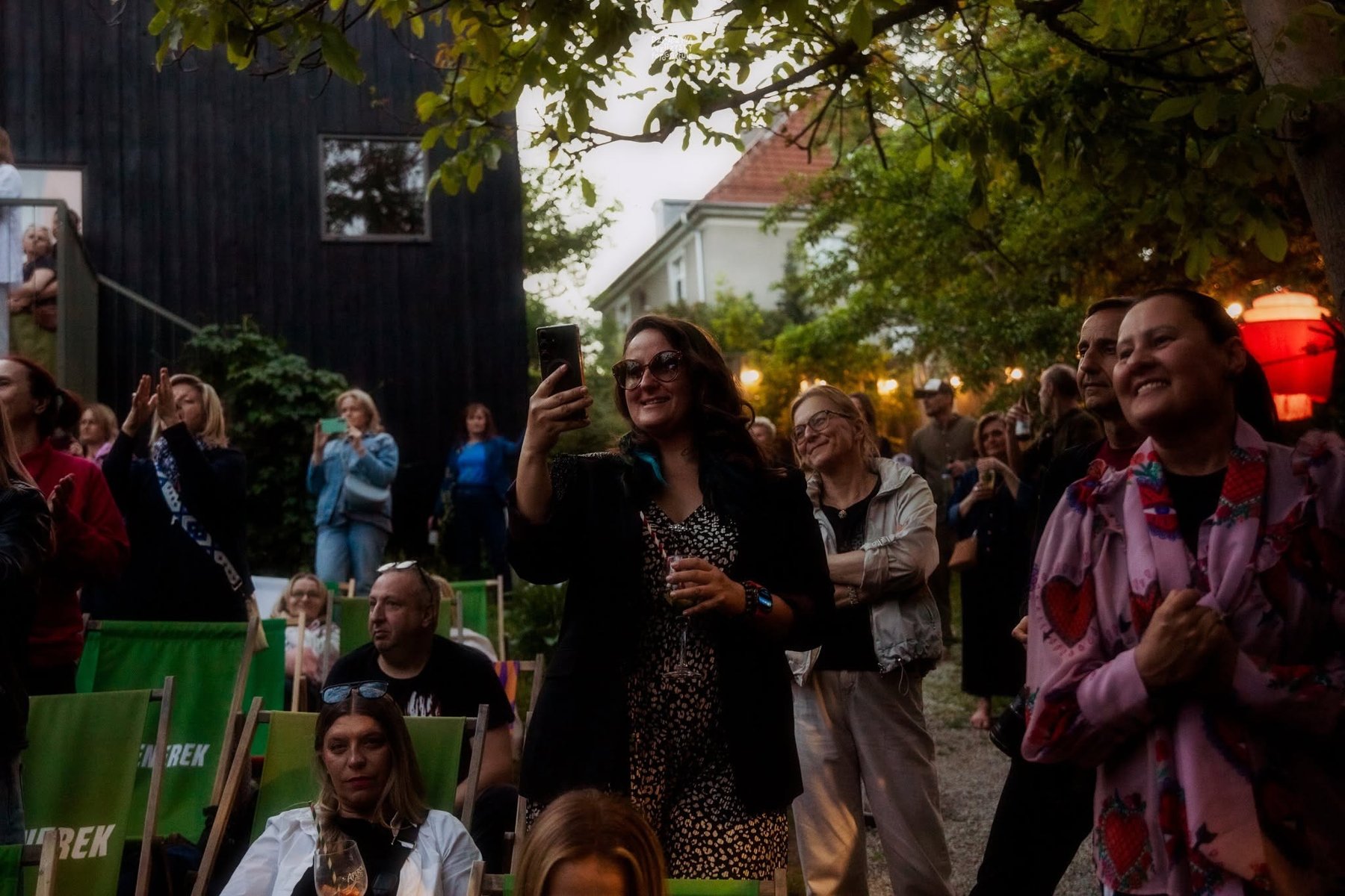 Roześmiana publiczność na plenerowym wydarzeniu.