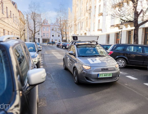 Samochód e-kontroli SPP na ulic. Po obu jej stronach widać zaparkowane auta