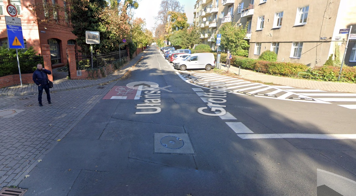 Skrzyżowanie ul. Ułańskiej i Grottgera w miejscu planowanego zamknięcia, przejście dla pieszych i budynki po obu stronach asfaltowej ulicy