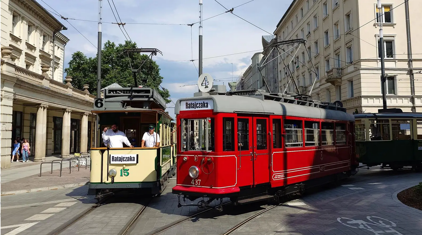 Tramwaje historyczne z numerami 6 (tramwaj beżowy) i 4 (tramwaj czerwony) spotykają się na skrzyżowaniu ulic Poznania.
