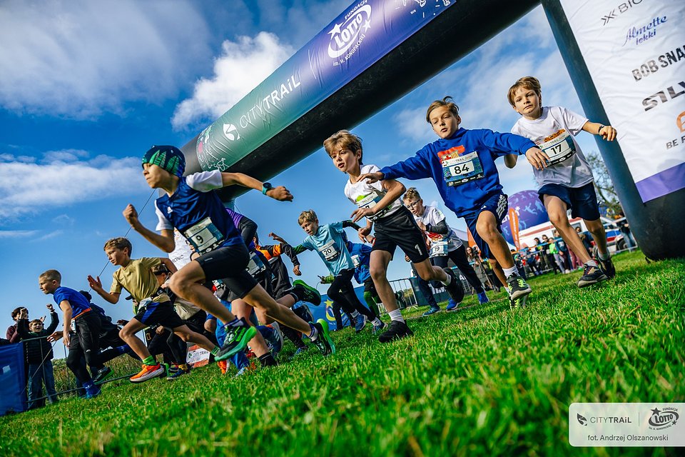 Uczestnicy biegu CITY TRAIL Junior na trasie, fot. Andrzej Olszanowski - dzieci rozpoczynają bieg po trawie
