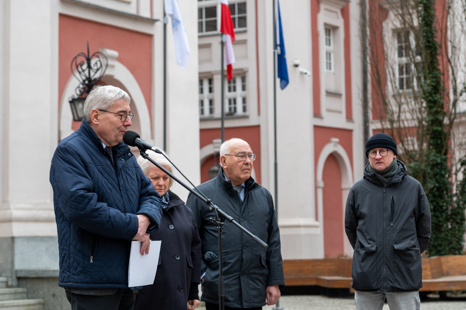 Uczestnicy konferencji podczas przemawiania. Sytuacja ma miejsce na dziedzińcu urzędu