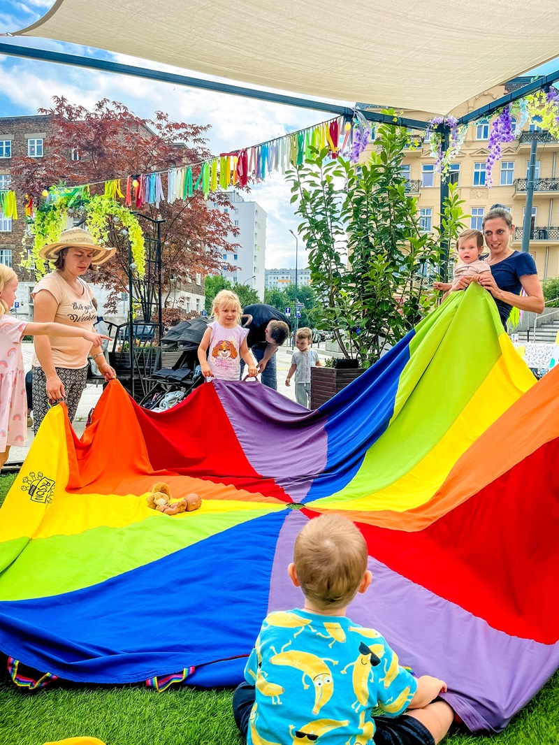 Uczetsnicy animacji trzymają tkaninowe koło z kolorwych barw