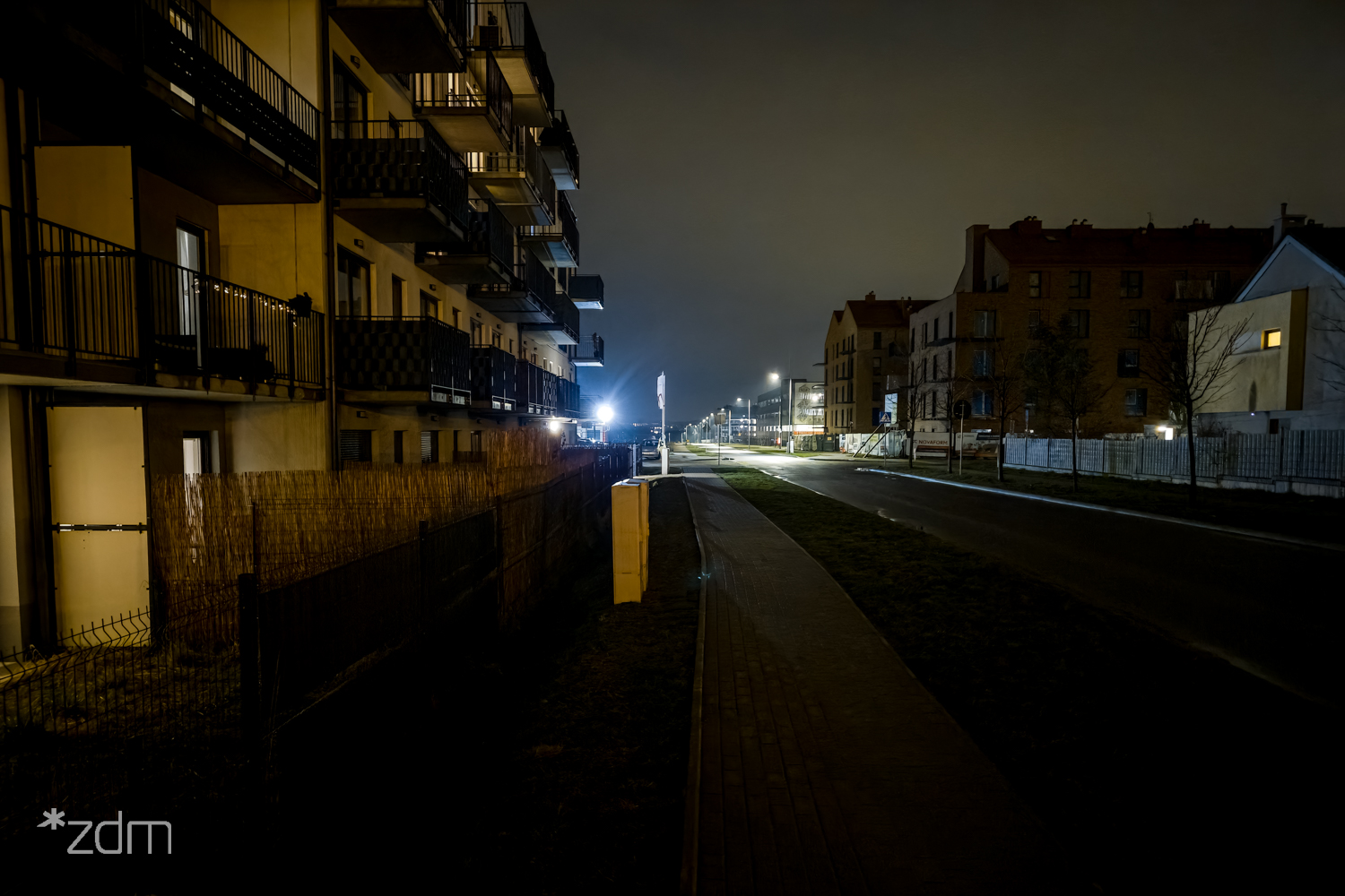 Ulica Czarnucha nieoświetlona nocą, z lewej ciąg bloków moieszkalnych