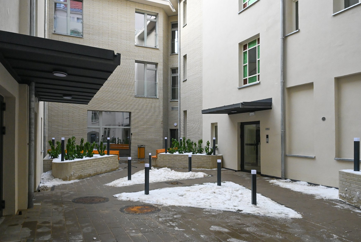 widok od strony wewnętrznego dziedzińca kamienicy, widoczne wejścia do budynku i mała zieleń