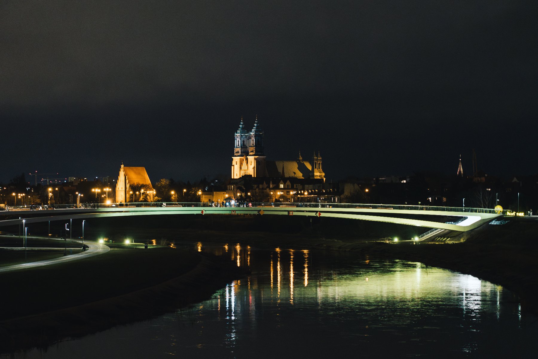 Widok z oddali w porze nocnej na budynek oświetlonego kościoła i podświetlony noc - panorama.