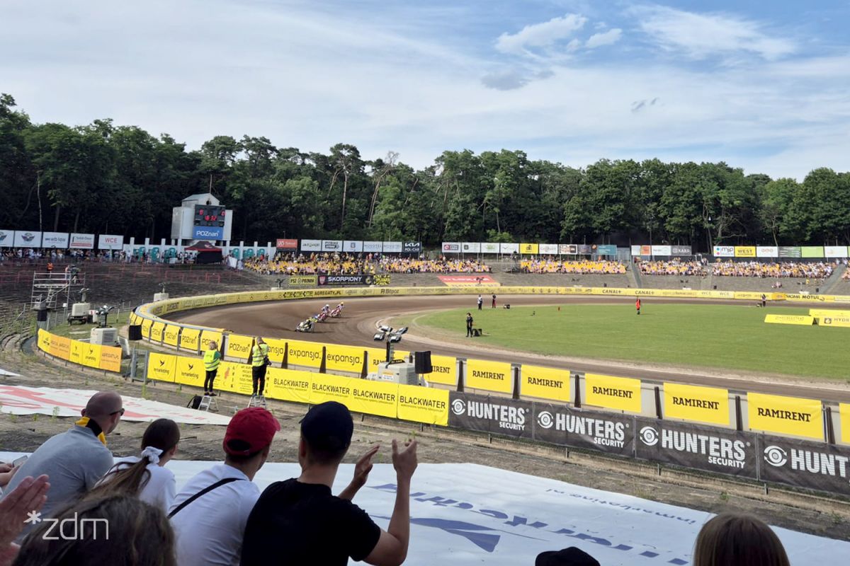 Widok z trybum na stadion żużlowy i ścigających się żużlowców