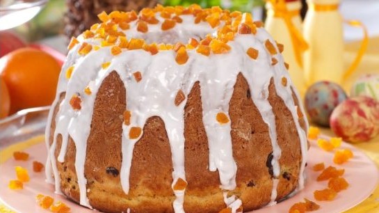 Wielkanocna baba drożdżowa, udekorowana lukrem i skórką pomarańczową.