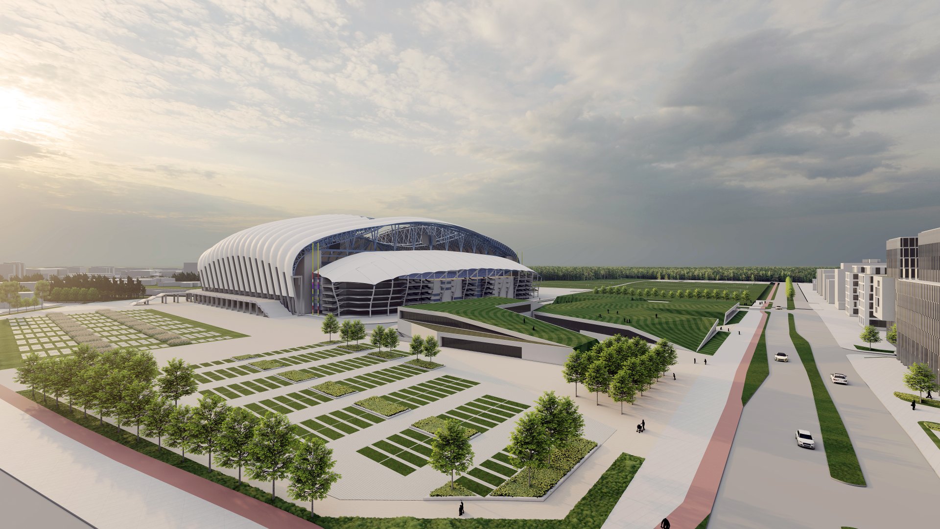 Wizualizacja architektoniczna nowoczesnego kompleksu sportowego, przedstawiająca stadion o unikalnej konstrukcji z białym, żebrowanym dachem. Na pierwszym planie widoczne są rozległe parkingi z geometrycznie wydzielonymi miejscami postojowymi oraz niską roślinnością i rzędami młodych drzew. Obok stadionu znajdują się budynki o dachach pokrytych zielenią, które płynnie przechodzą w tereny rekreacyjne.
