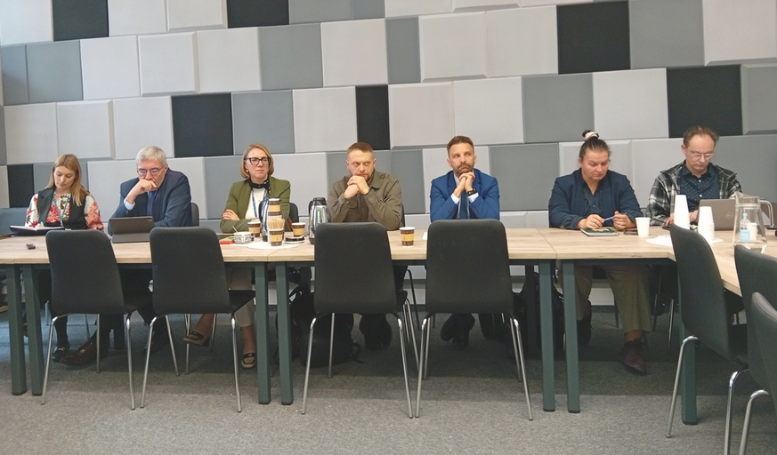 za stołem w sali konferencyjnej obradu kilka osób - więcej w treści artykułu