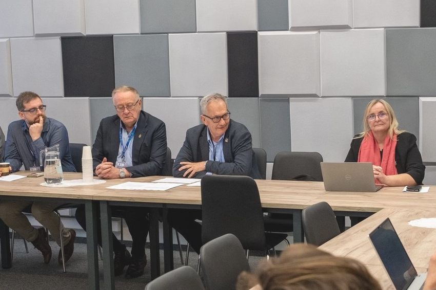 za stołem w sali konferencyjnej obraduje kilka osób - więcej w treści artykułu