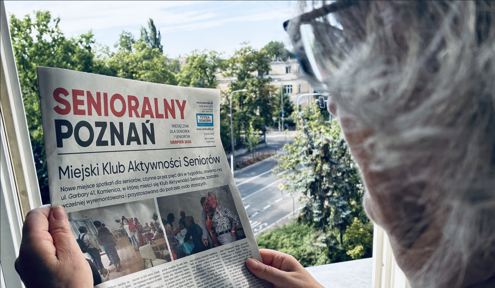 Zdjęcie Kobietę stojącą w oknie i czytająca gazetę "Senioralny Poznań"