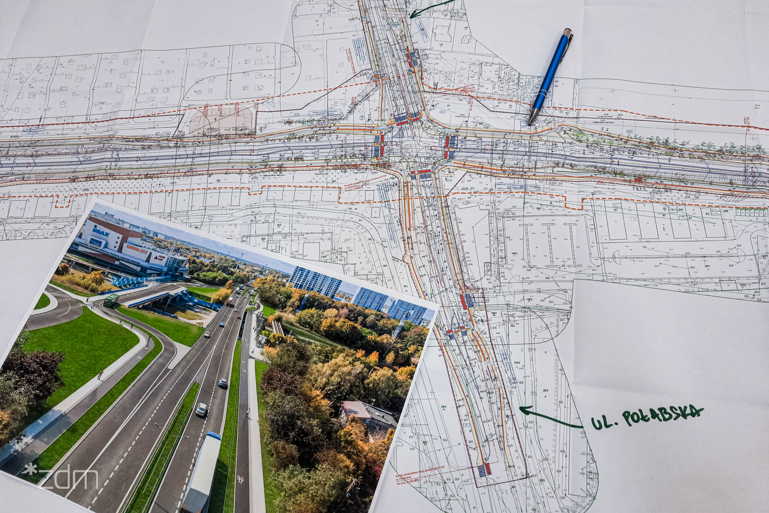 Zdjęcie - Na stole leży koncepcja przebudowy ul. Lechickiej, długopis oraz wizualizacja nowego rozwiązania drogowego.