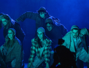 Zdjęcie przedstawia aktorów w płaszczach i czapkach na głowie patrzących groźnym wzrokiem.