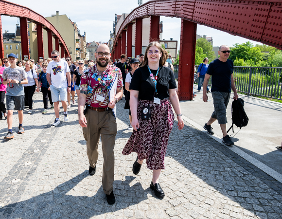 Zdjęcie przedstawia dużą grupę ludzi idących mostem Biskupa Jordana.