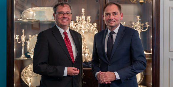 Zdjęcie przedstawia dwóch stojących obok siebie mężczyzn.