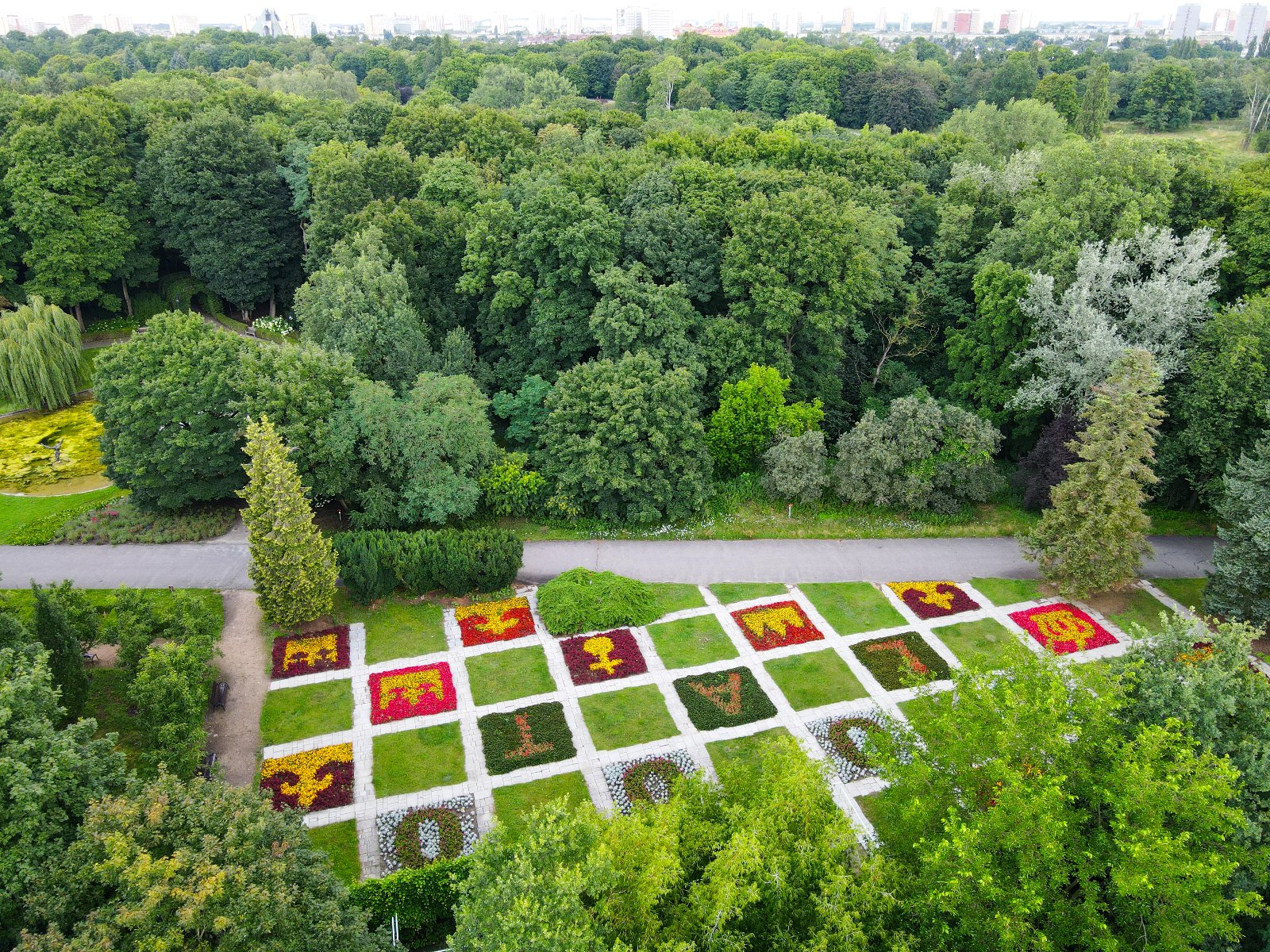 Zdjęcie przedstawia instalację kwiatową ułożoną w kształcie królewskich insygni - korony i berła oraz napis 1000 lat. Zdjęcie zrobiono z lotu ptaka.