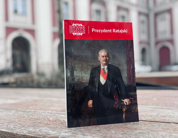 Zdjęcie przedstawia książkę, na której okładce znajduje się starszy mężczyzna - Cyryl Ratajski. Książka stoi na ławce na dziedzińcu urzędu.