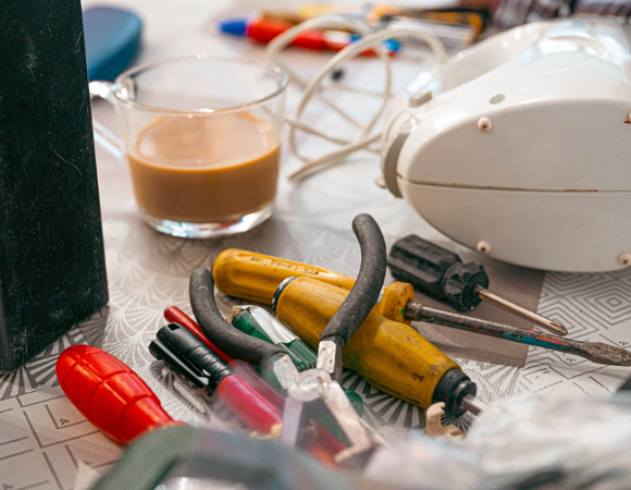 Zdjęcie przedstawia leżące na stole narzędzia i mikser oraz szklankę z kawą.