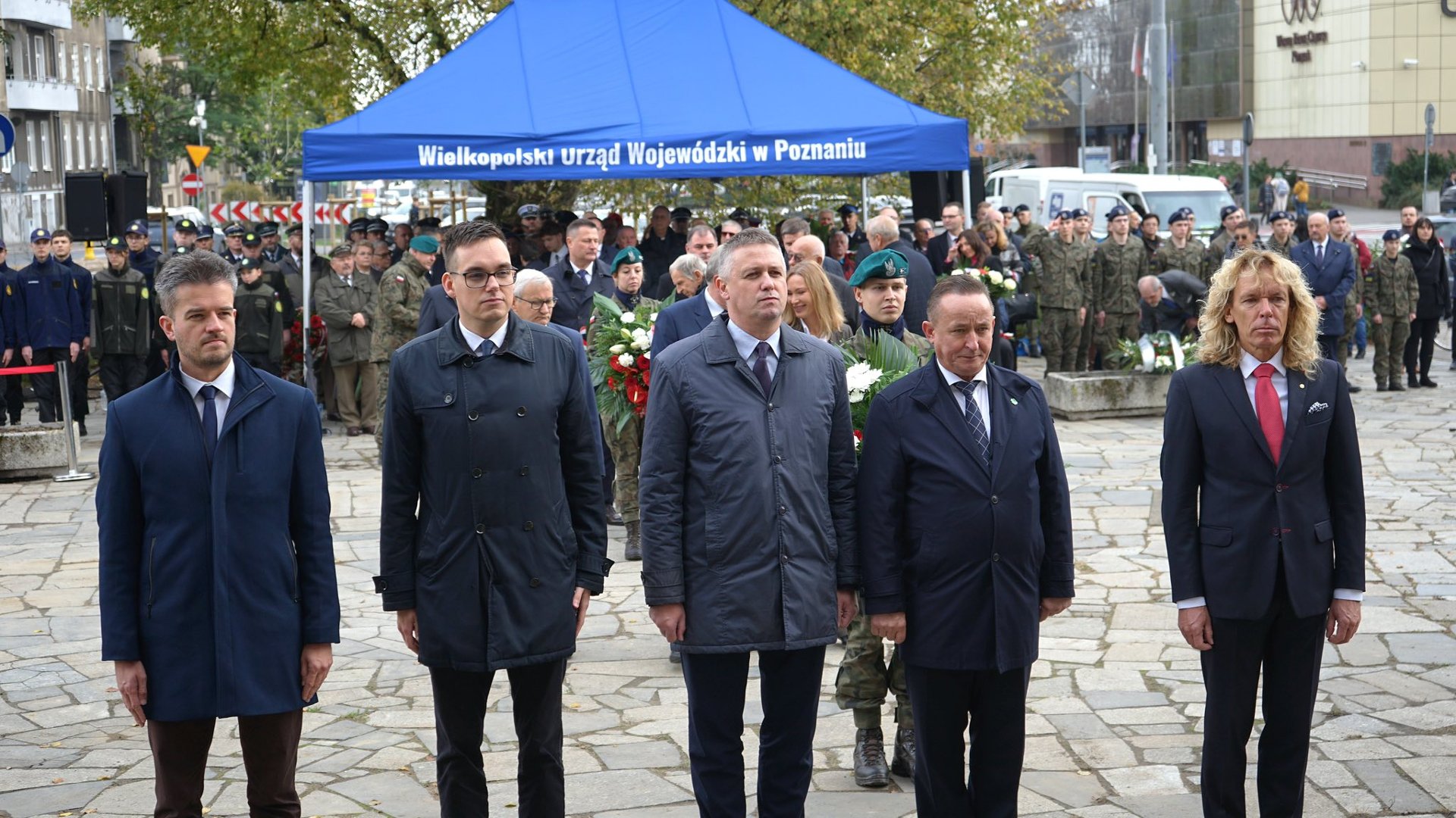 Zdjęcie przedstawia moment składania kwiatów przed pomnikiem.