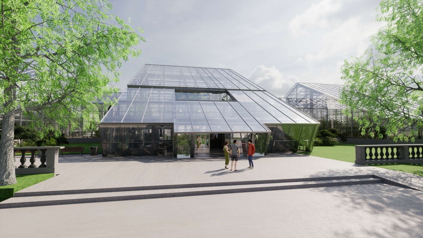 Zdjęcie przedstawia nowoczesną wizualizację architektoniczną dużego przeszklonego budynku, który przypomina oranżerię lub palmiarnię. Konstrukcja posiada spadziste, szklane dachy oparte na ciemnym stelażu, a w centralnej części widoczne jest wejście, przy którym stoi troje ludzi. Budynek otoczony jest zadbanym terenem z jasnym, betonowym placem na pierwszym planie, zielonymi trawnikami oraz drzewami o gęstym, jasnozielonym listowiu.