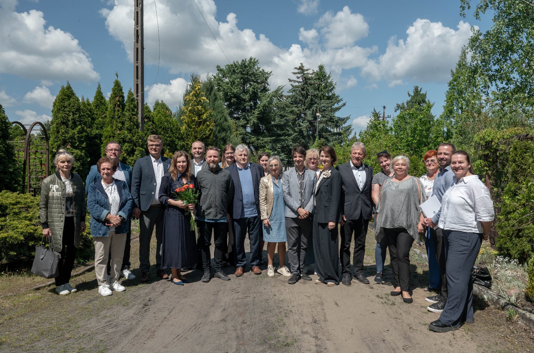Zdjęcie przedstawia ogród działkowy. Widać na nim zieleń i ozdobne figurki bocianów.