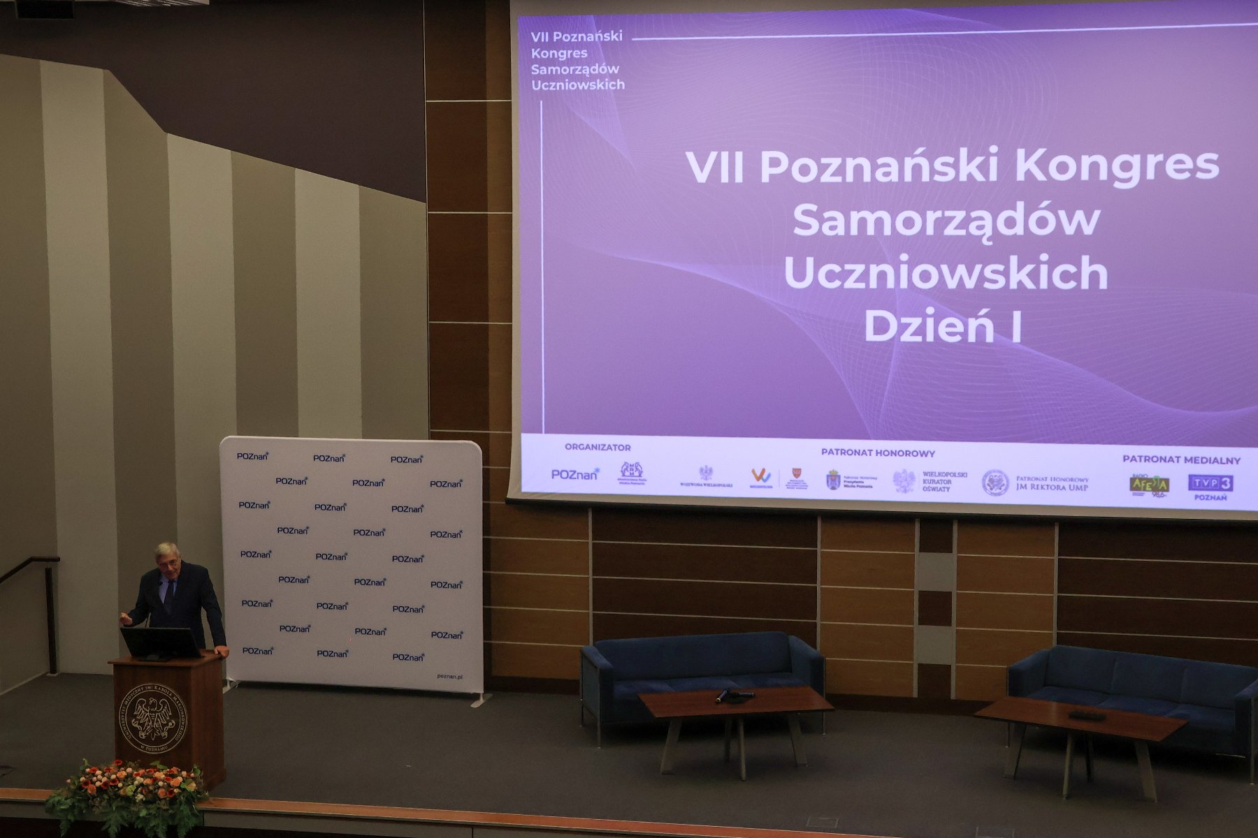Zdjęcie przedstawia przemawiającego w auli przewodniczącego rady miasta.