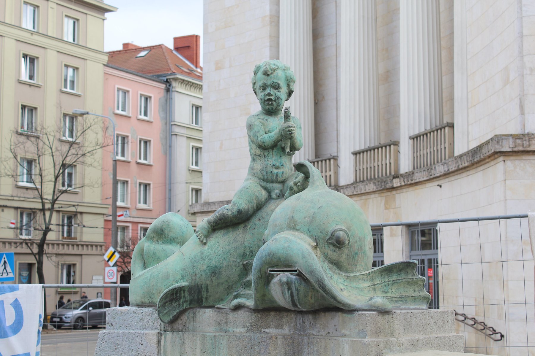 Zdjęcie przedstawia rzeźbę chłopczyka siedzącego na delfinie.