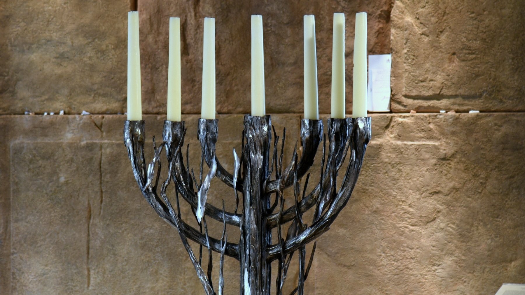 Zdjęcie przedstawia siedmioramienny świecznik - menorę - wykonany w unikalnym, artystycznym stylu.