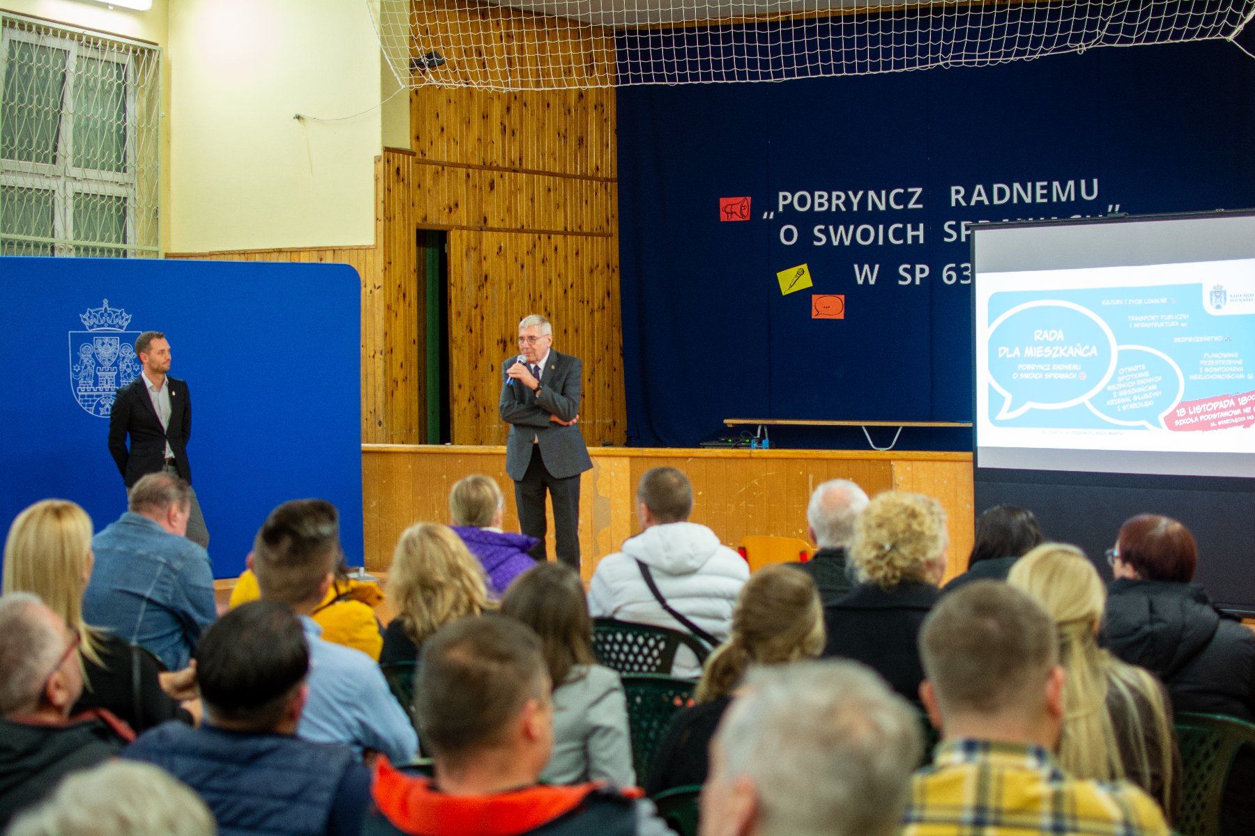 Zdjęcie przedstawia spotkanie mieszkańców w sali sportowej.