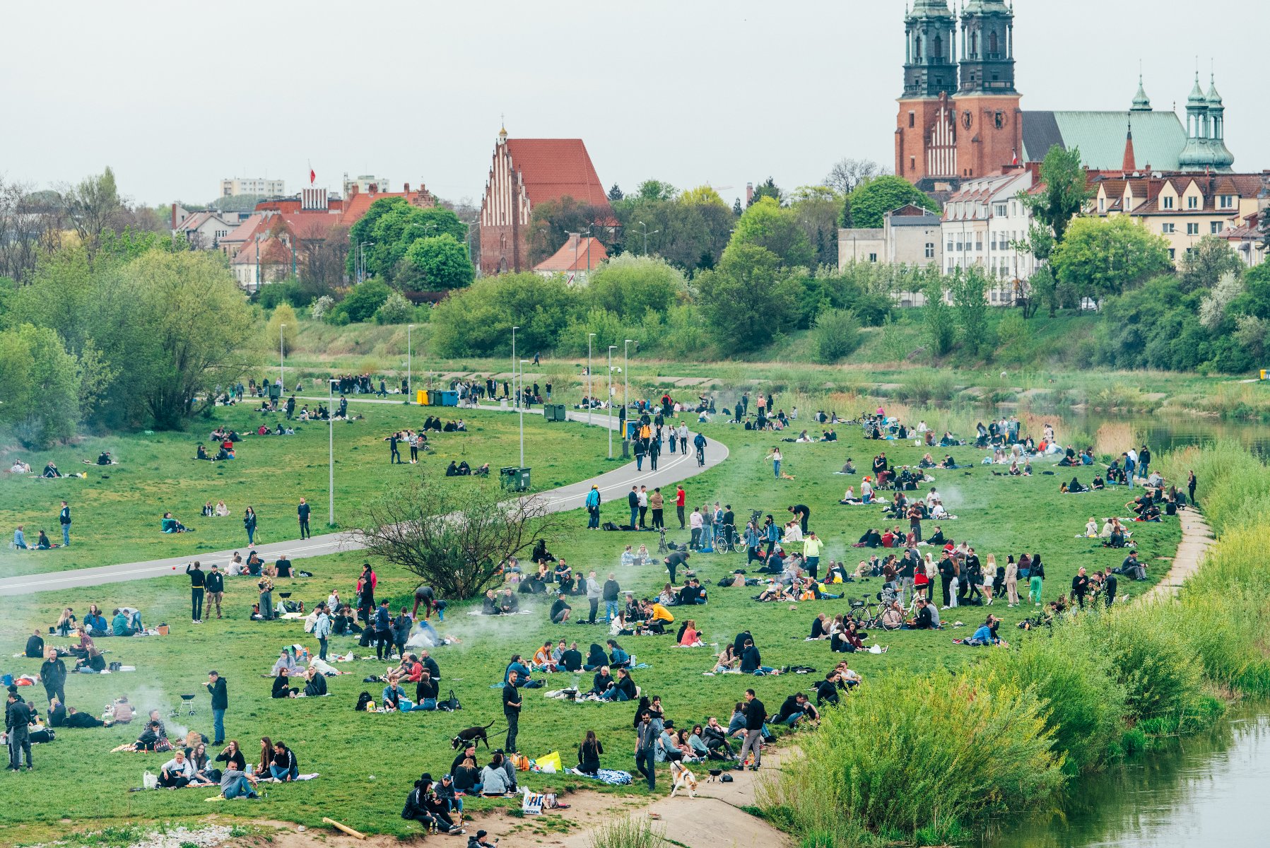 Zdjęcie przedstawia tłum ludzi wypowczywających nad rzeką.