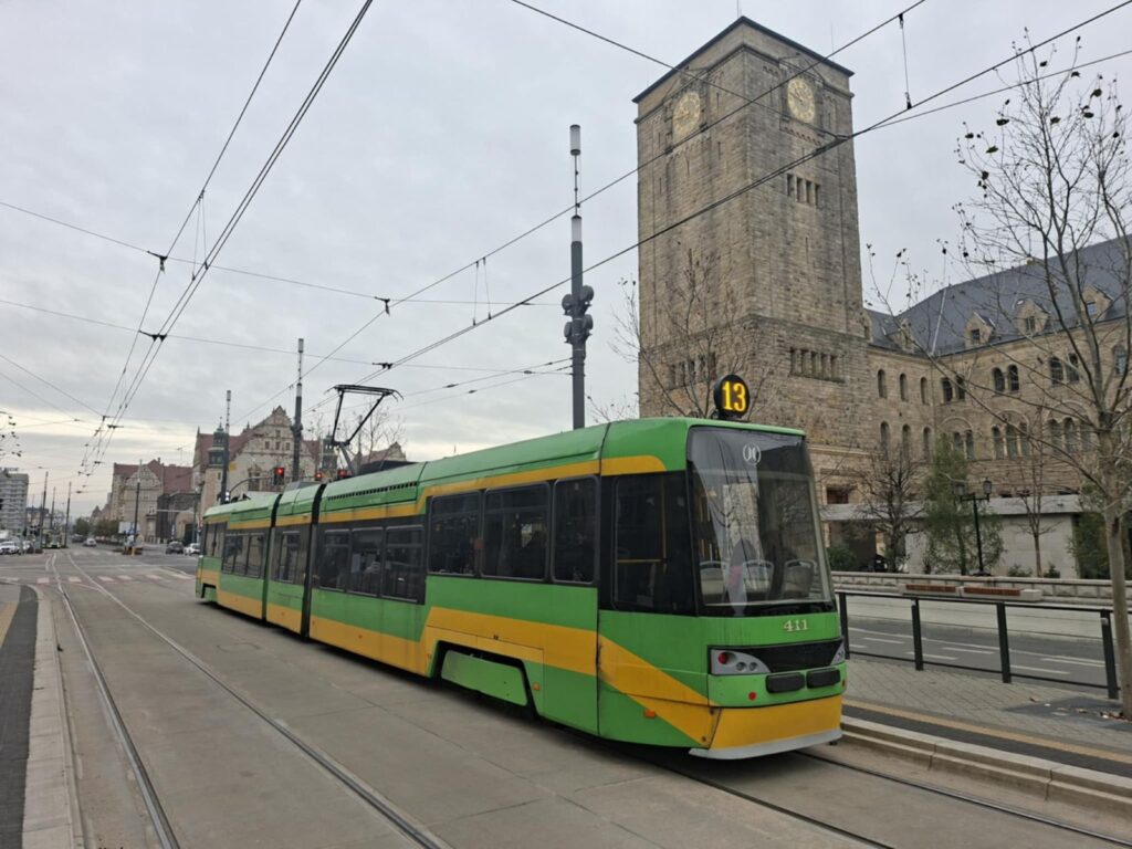 Zdjecie przedstawia tramwaj numer 13 na tle Zamku Cesarskiego w Pozaniu