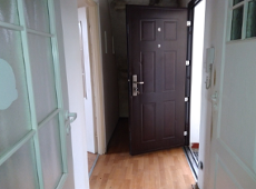 Zdjęcie przedstawia wnętrze mieszkania. Widać na nim korytarz i drzwi.