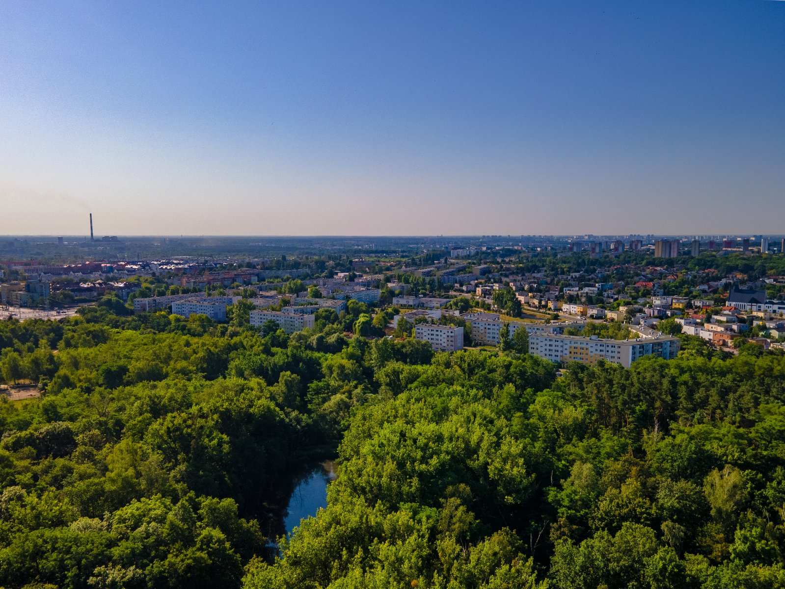 Zdjęcie przedstawia zieleń i budynki z lotu ptaka.