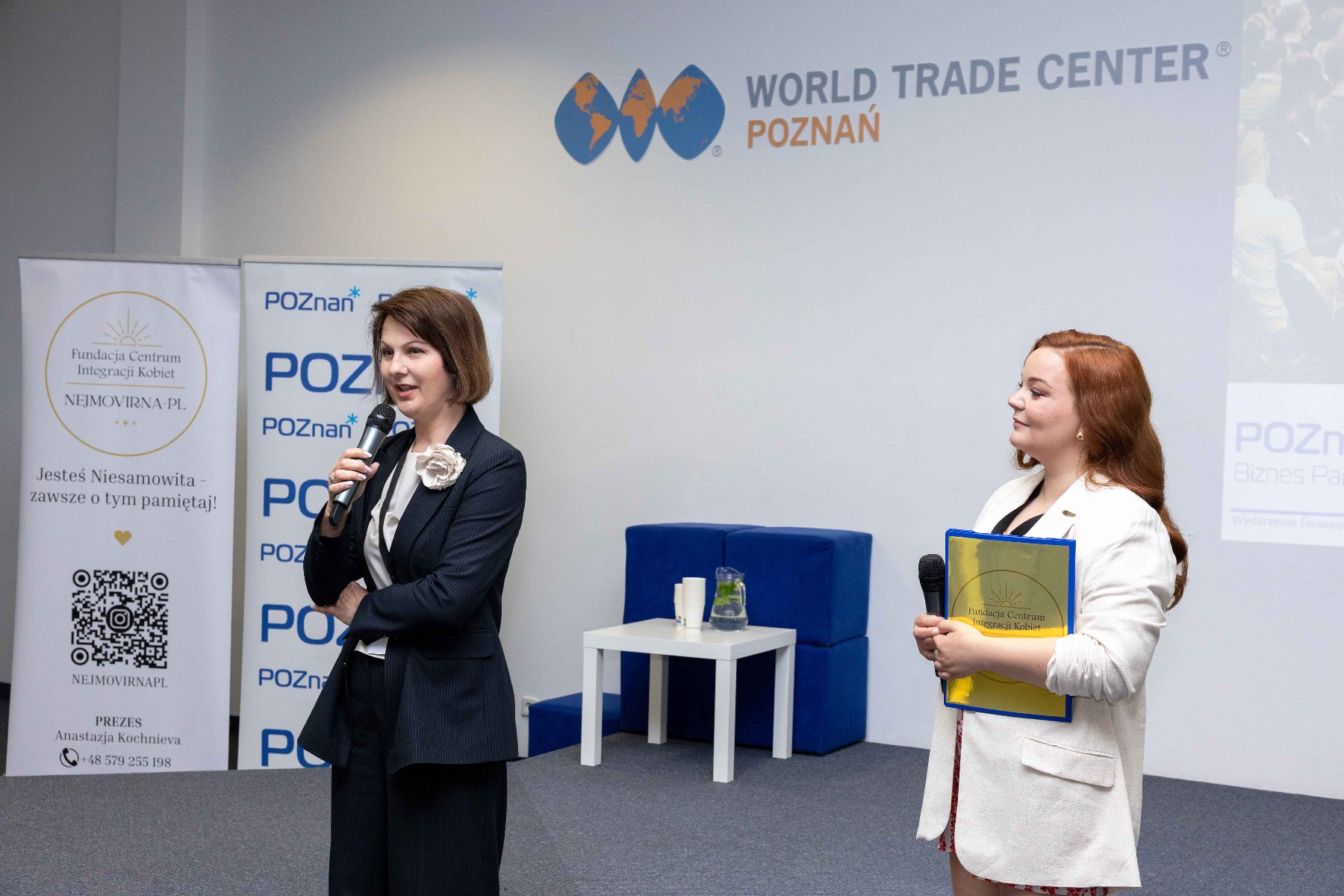 Zdjęcie przedstawiające dwie kobiety, Dyrektor WDGiR, Joannę Jajus oraz Prezeskę Fundacji Centrum Integracji Kobiet Nejmovirna PL, które witają uczestników konferencji