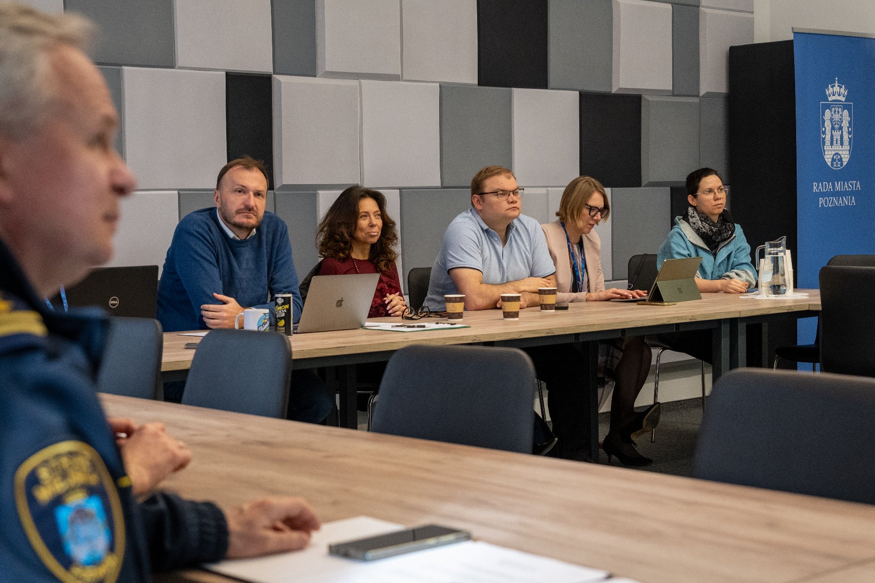 Zdjęcie z posiedzenia komisji. Radni siedzą przy stole.