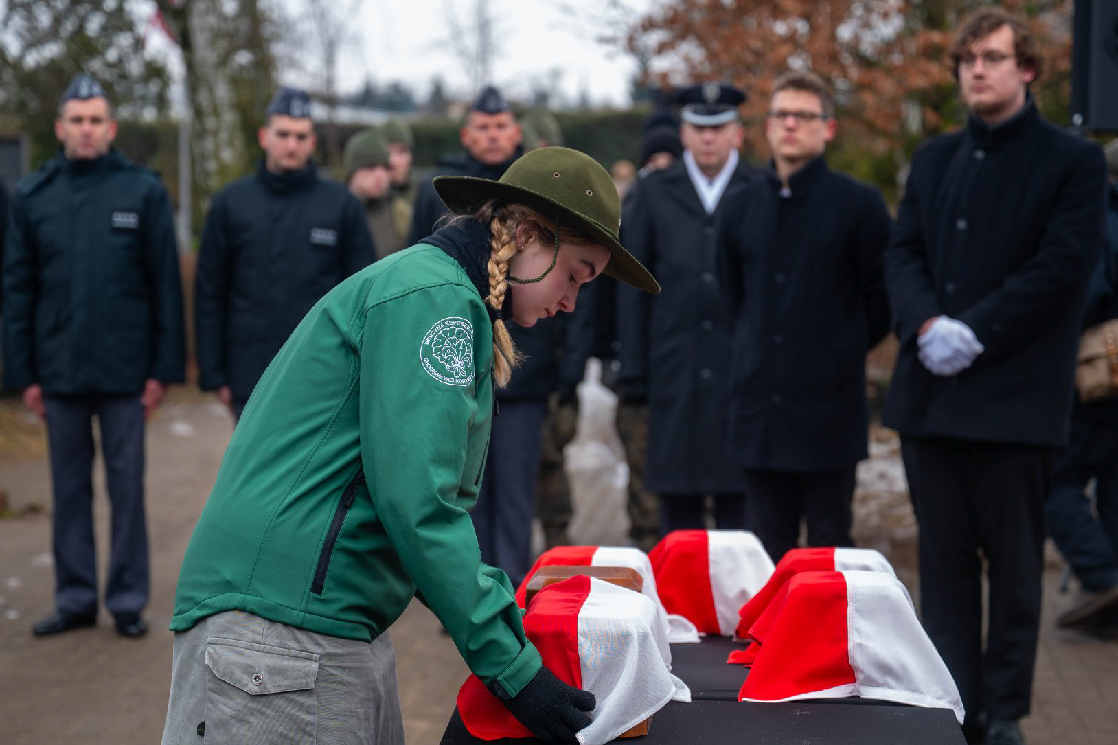 Zdjęcie z uroczystości. Harcerka trzyma urnę.
