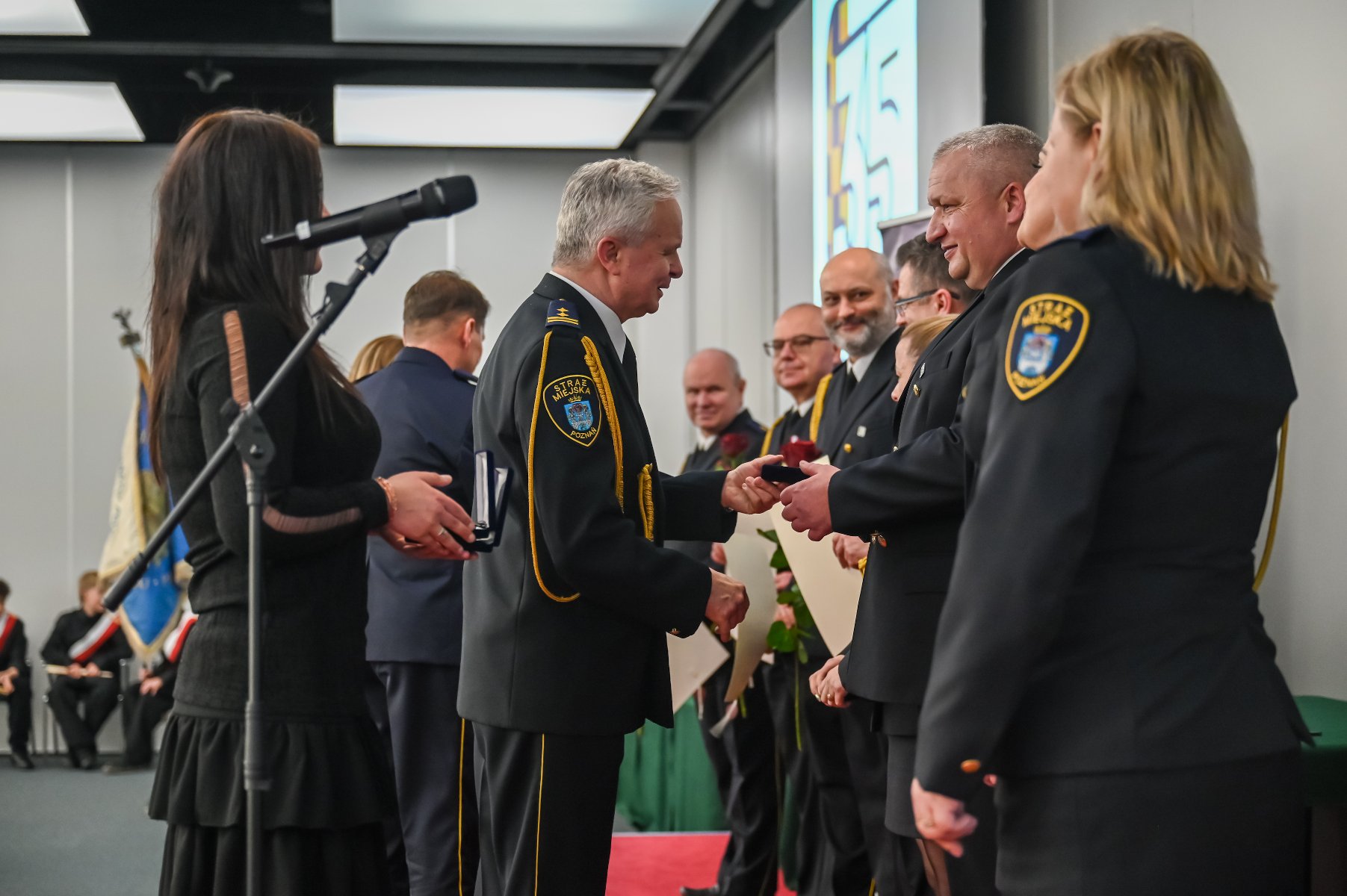 Zdjęcie z uroczystości. Moment wręczania gratulacji.