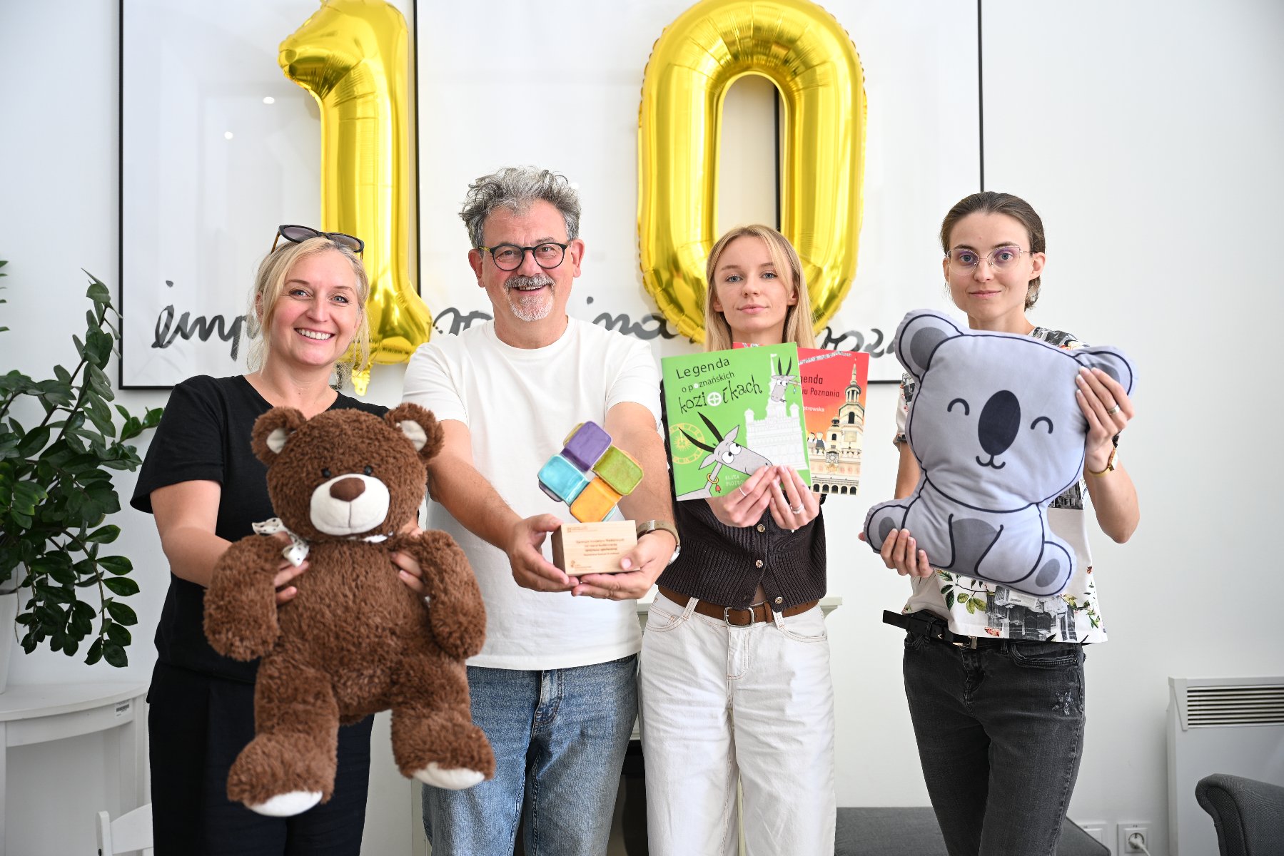 zespół pracujący w siedzibie Centrum Inicjatyw Rodzinnych z balonem - 10 lat, maskotkami, książkami dla dzieci