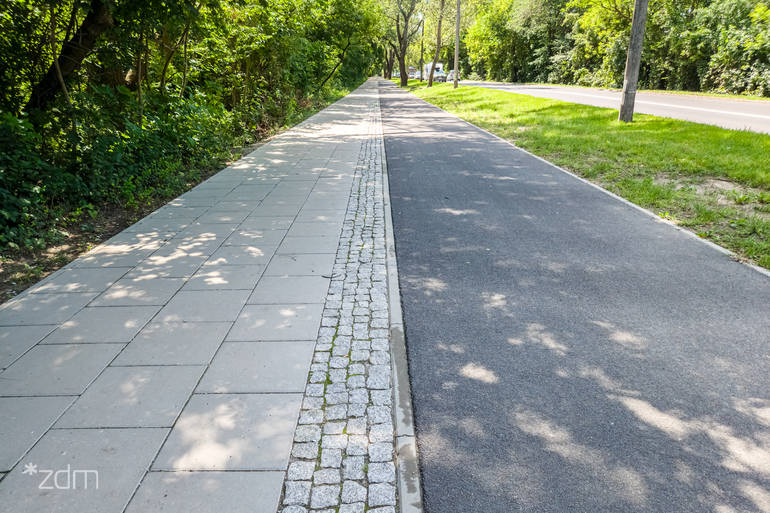 Galeria zdjęć z drogi dla rowerów przed jej modernizacją - widok na asfaltową drogę dla rowerów i drogę dla pieszych z płyt betonowych