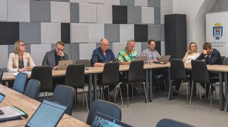 kilkoro osób siedzi za stołem w sali konferencyjnej - grafika artykułu