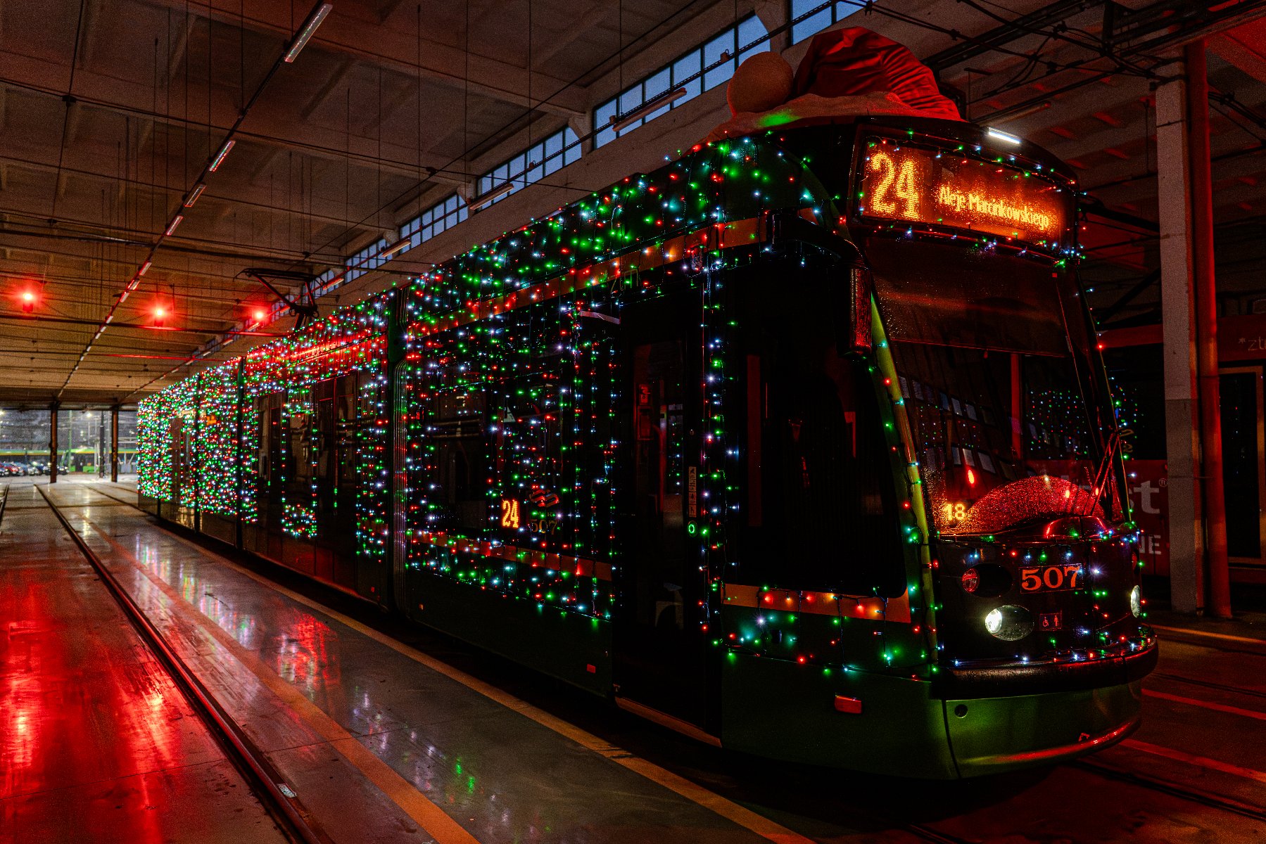 Na zdjęciu ozdobiony światełkami tramwaj, stojący w zajezdni